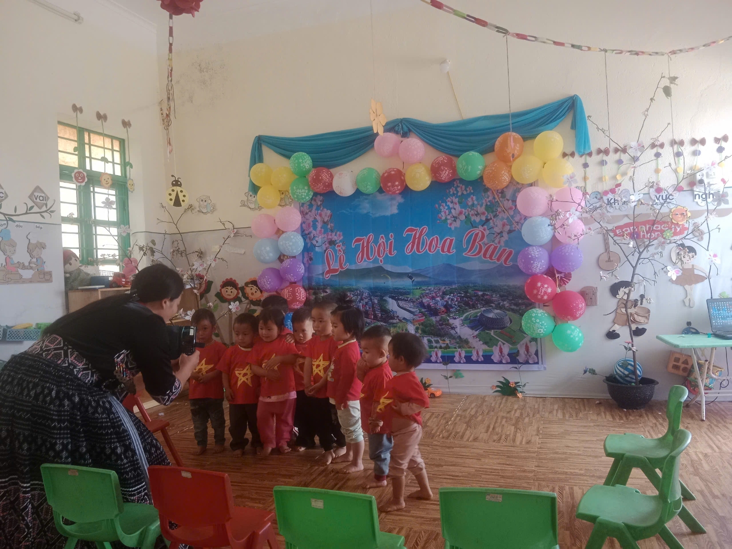 cô chụp ảnh cho trẻ đi chơi Lễ hội Hoa ban