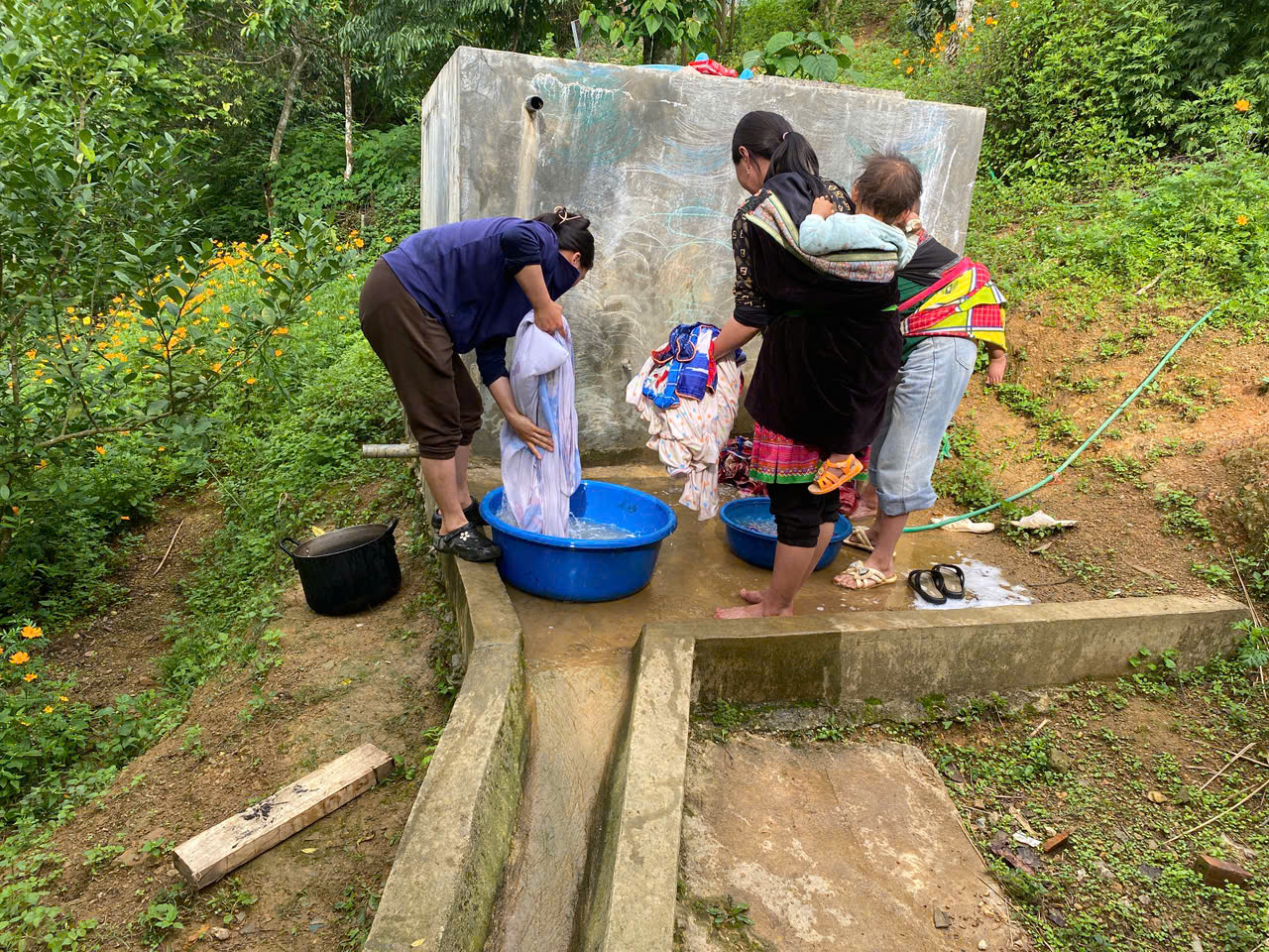 Hình ảnh 1 phụ huynh đang giặt vỏ gối, vỏ chăn